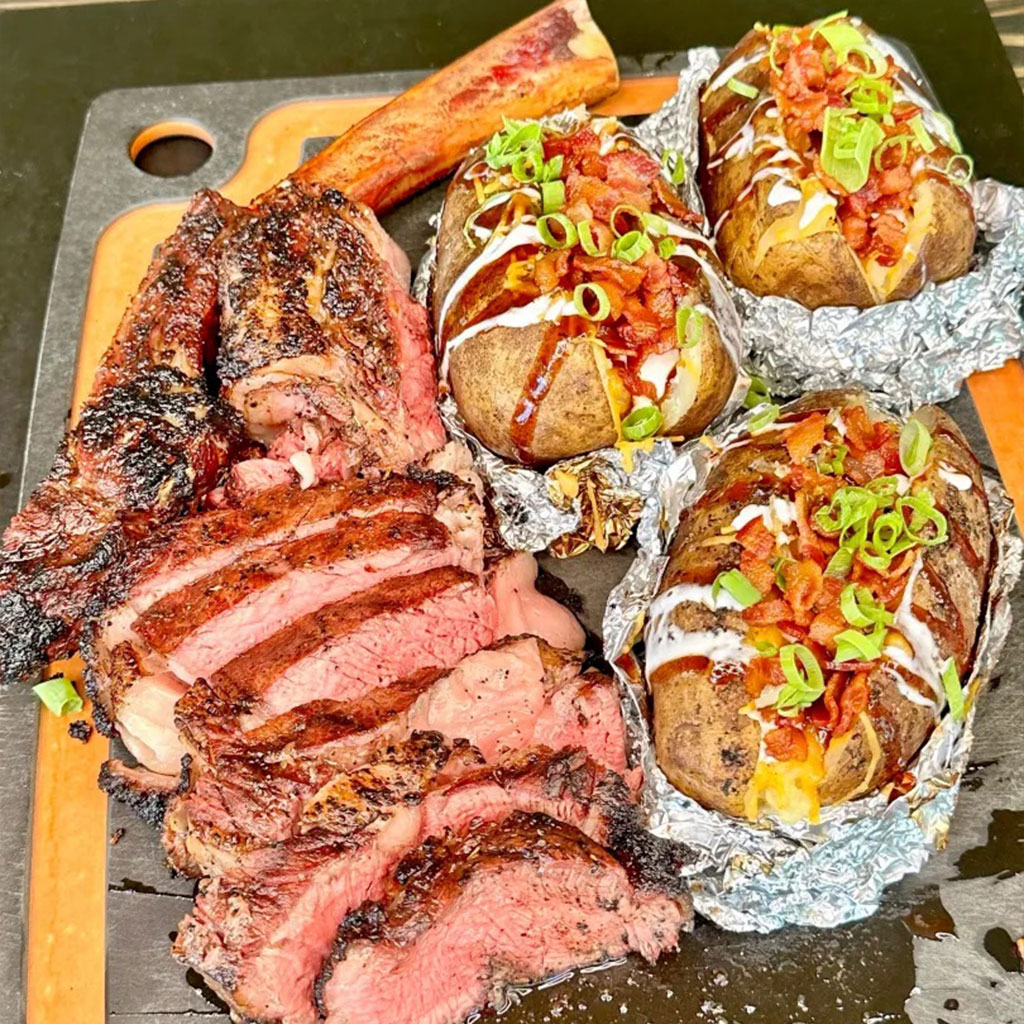 Grilled Tomahawk Ribeye Steak with loaded baked potatoes